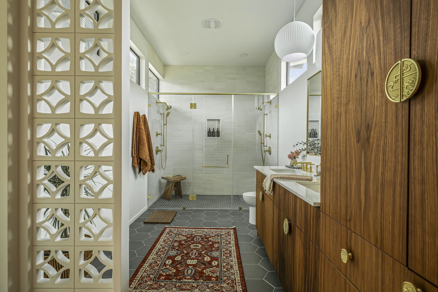 spacious walk-in shower with glass enclosure and dual shower heads in custom bathroom by RedOven Builds Rio Grande TX