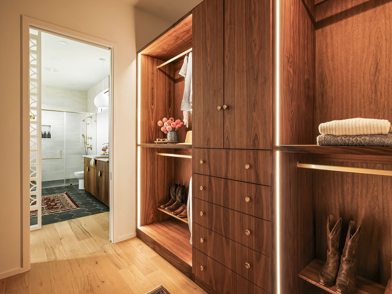 walk-in closet with built-in wood drawers and hanging storage by RedOven Builds in Rio Grande TX