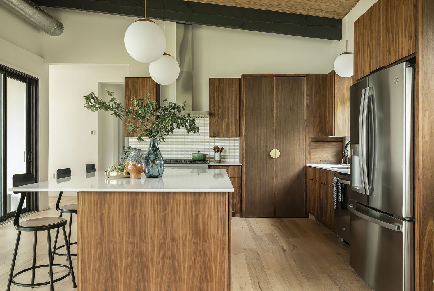 wide angle kitchen with island seating and wood cabinets by RedOven Builds San Juan Dr Rio Grande TX