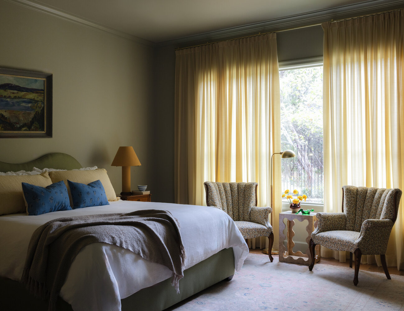 Cozy bedroom design in Austin TX full renovation by RedOven Builds with upholstered bed and natural light