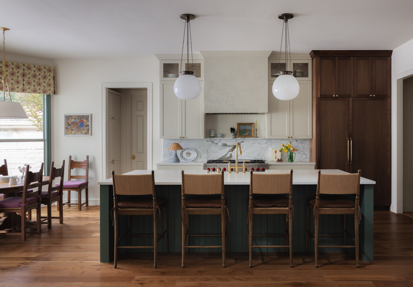 Full gut kitchen renovation in Austin TX by RedOven Builds featuring white cabinetry, wood accents, and bar stools
