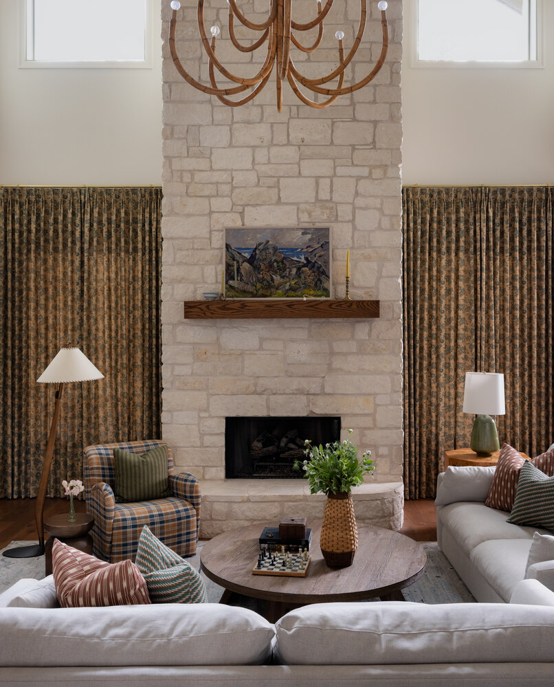 Warm living space in Austin TX full remodel by RedOven Builds featuring fireplace and layered textiles