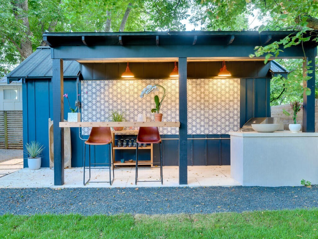 Backyard kitchen addition in Austin by RedOven Builds featuring modern bar and outdoor cooking area