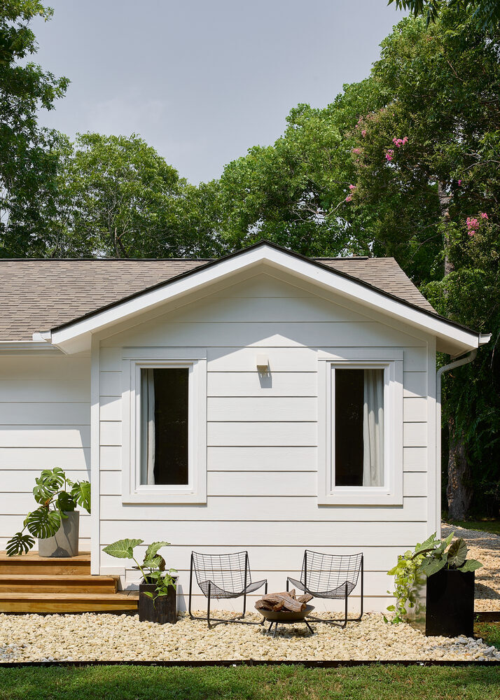 modern white exterior home with outdoor seating area by RedOven Builds whole home remodeling in Austin, TX